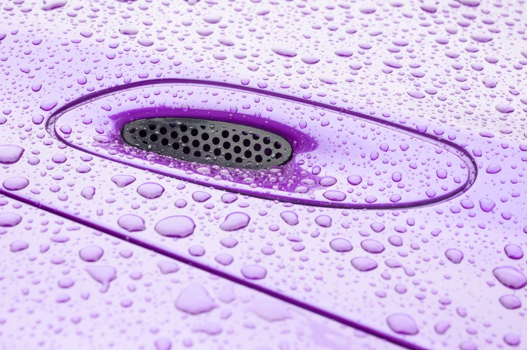 hood of a purple sports car displaying water beading