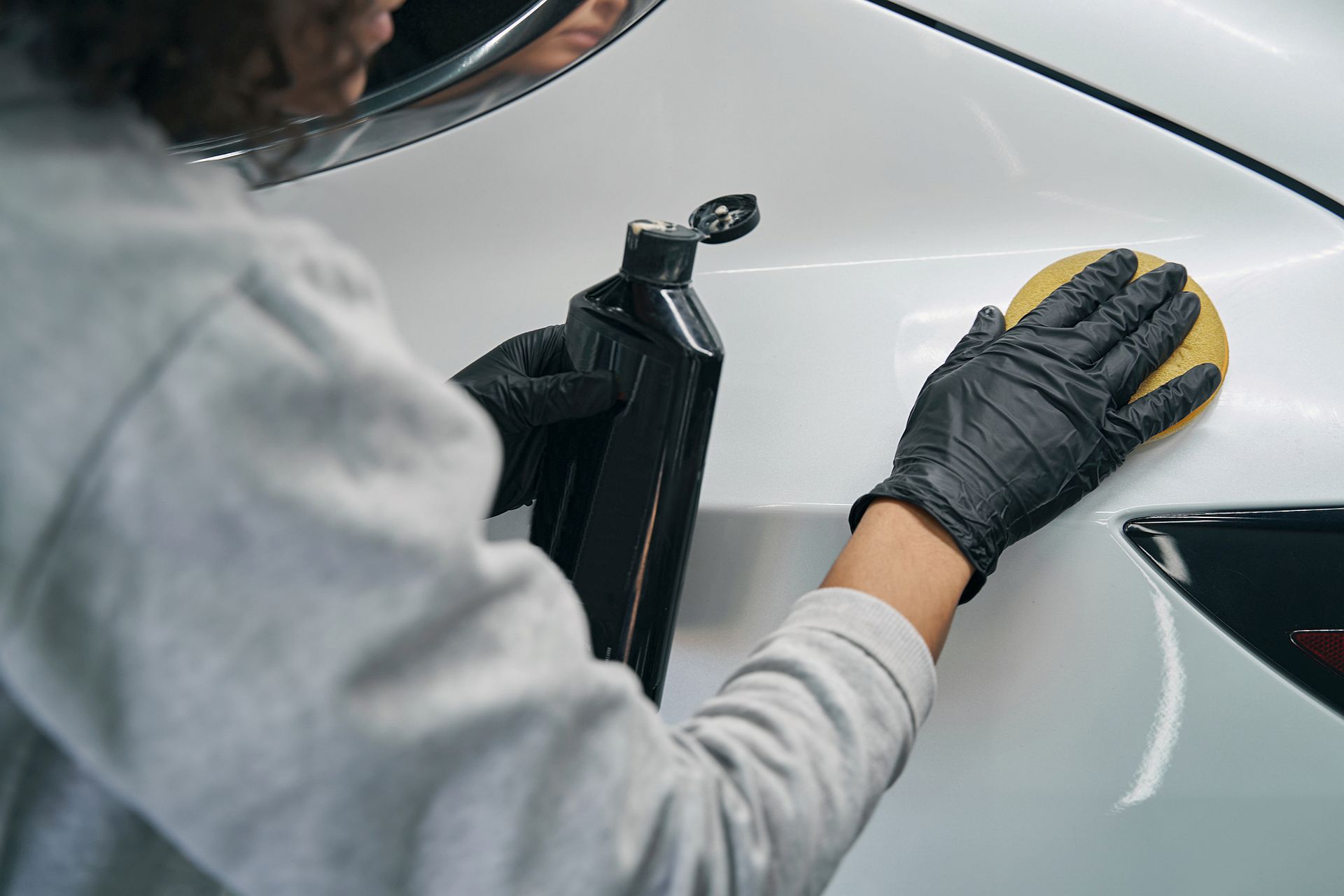 auto detailer hand applying car wax
